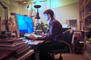 man working intently at computer in home office