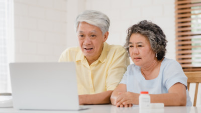 elderly asian couple view medical animation video on laptop at home