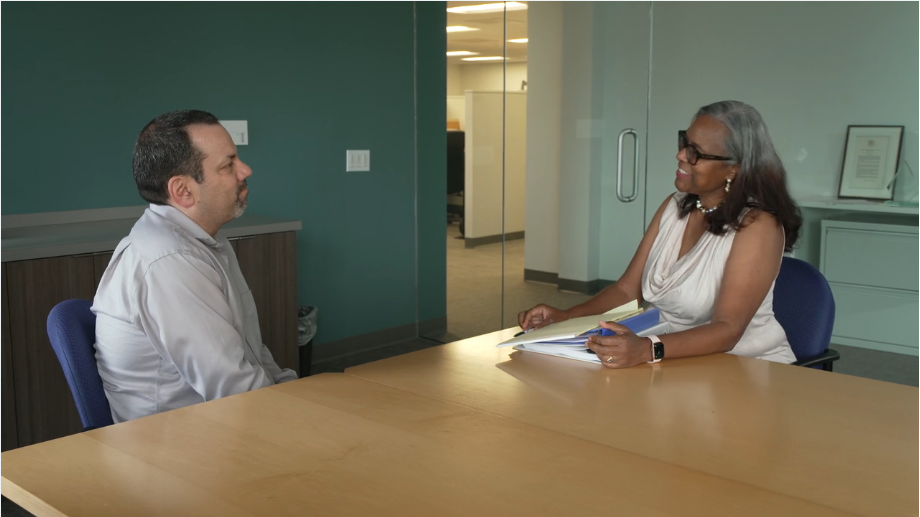 thumbnail of a scenario-based training video showing a scene of a patient meeting with HR rep in a workplace